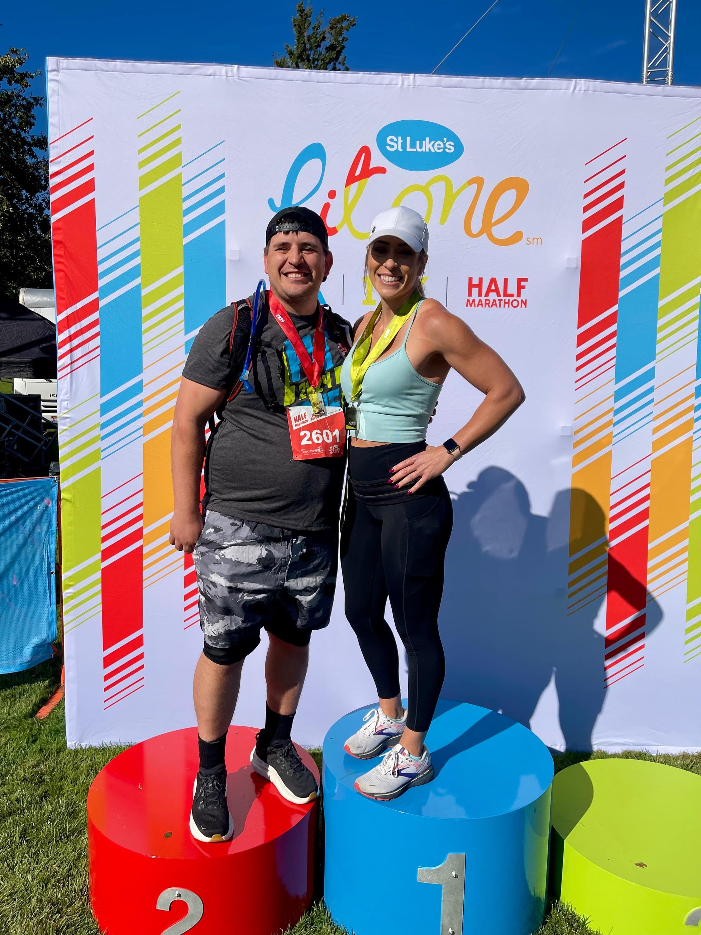 Male and female posing after a running face with trophies